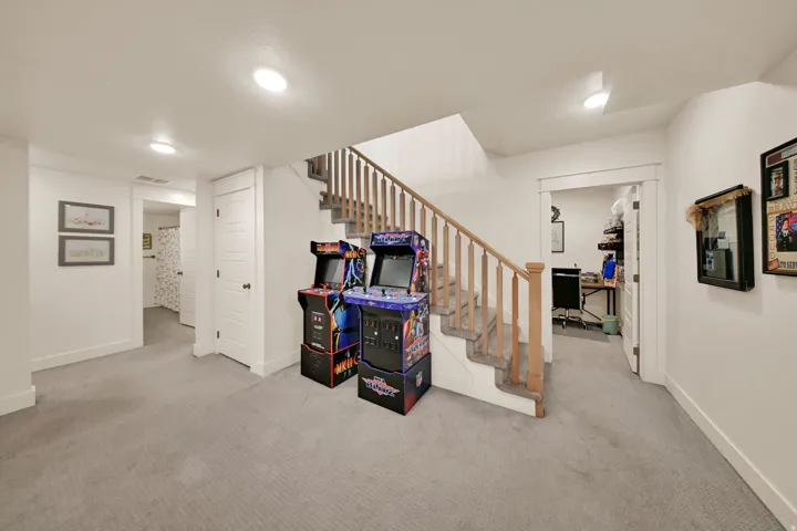 Carpeted flooring, white interior doors, and a wood-finish staircase with matching handrails and balusters