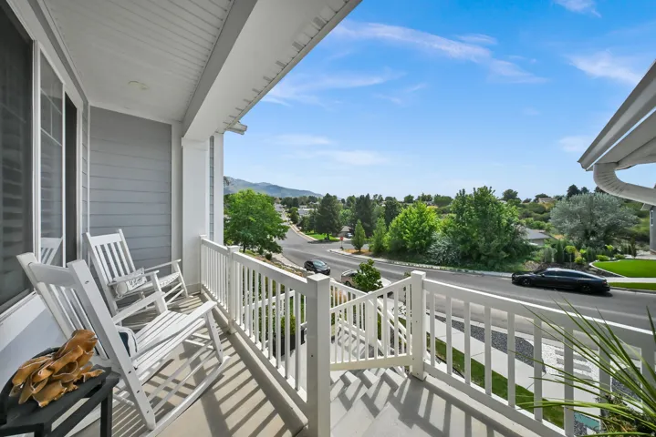 Front porch with a white railing, gray siding, and a white ceiling