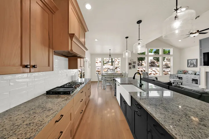 Kitchen featuring wood-finish cabinetry, light-toned countertops, and a white subway tile backsplash