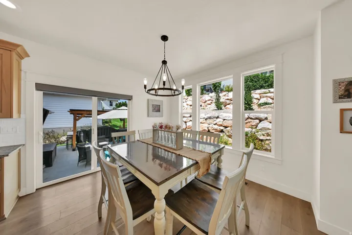 Wood-finish flooring throughout, white walls, and a black metal chandelier