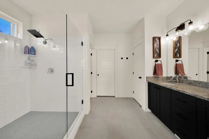 Glass-enclosed shower with subway tile surround and rain shower head