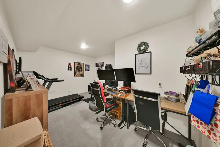 Recessed lighting illuminates a neutral-toned room with light gray flooring