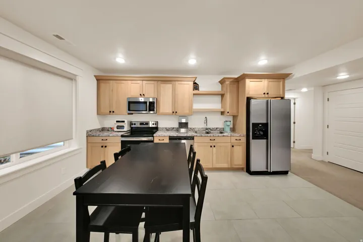 Kitchenette featuring wood cabinetry, stainless steel appliances, and a solid surface countertop