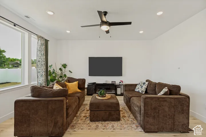 Recessed lighting, light wood-finish flooring, and a ceiling fan with integrated lighting