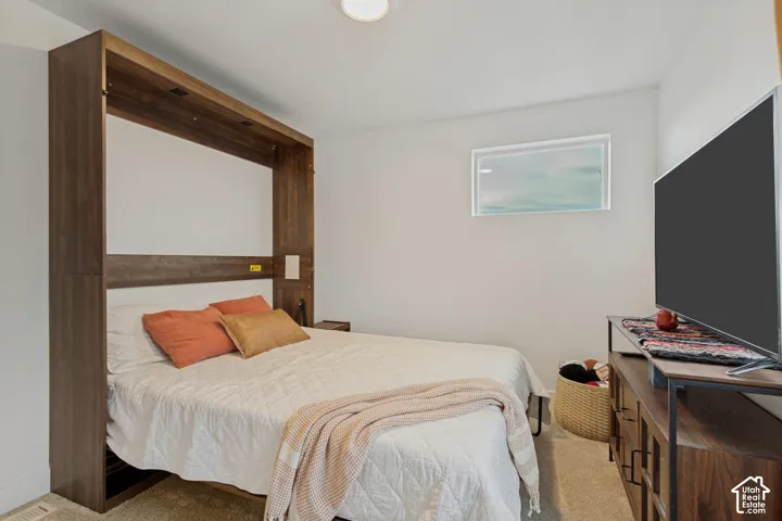 Built-in wall bed with integrated lighting, wood-finish cabinetry, and a horizontal window