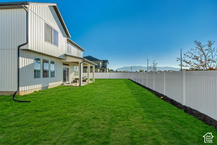 Expansive green lawn with a full privacy fence