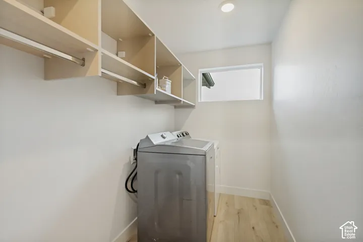 Built-in shelving with hanging rods, wood-finish flooring, recessed ceiling light, and a horizontal window