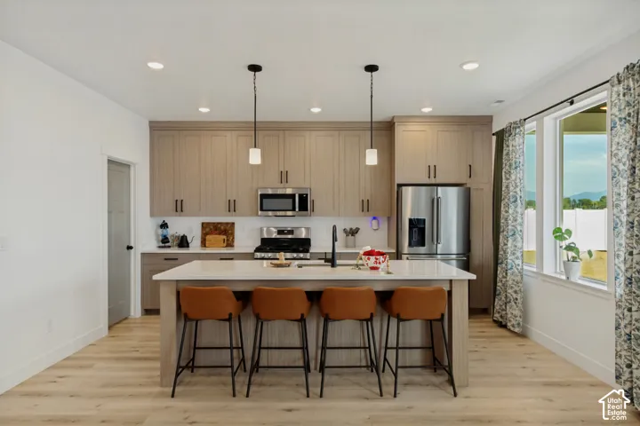 Kitchen featuring wood-finish flooring, recessed lighting, and a center island with pendant lights