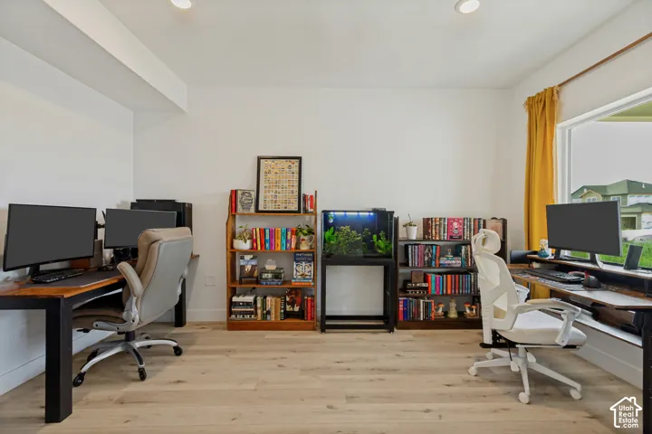 Hardwood-style flooring with white walls and recessed lighting