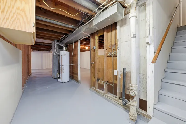 Utility space with painted concrete flooring, laundry hook ups & furnace.