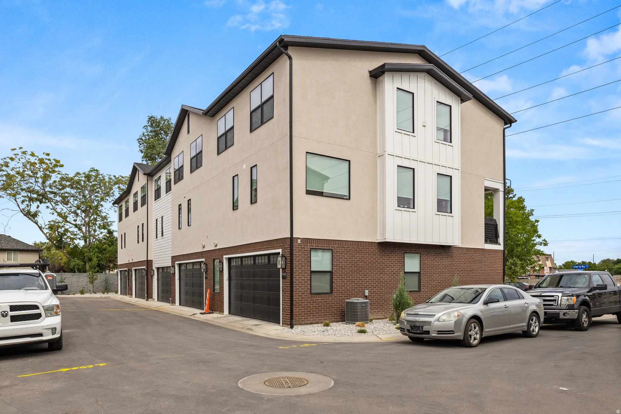Contemporary exterior with light stucco, dark brick, and vertical white siding accents