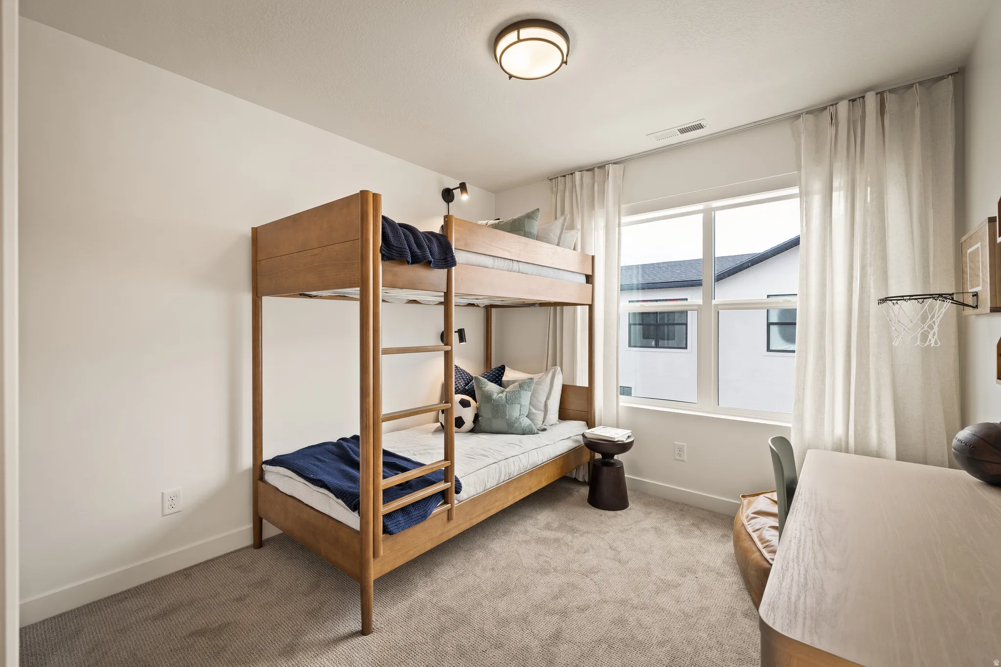 Recessed lighting, large window with natural light, neutral wall colors, and carpeted flooring