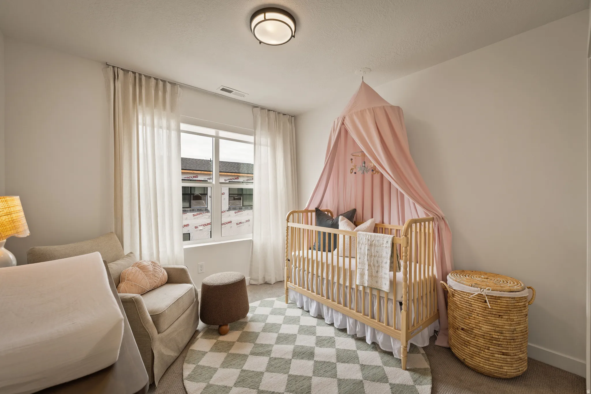 Recessed lighting fixture, light-toned wall paint, and double-paned window with sheer curtains