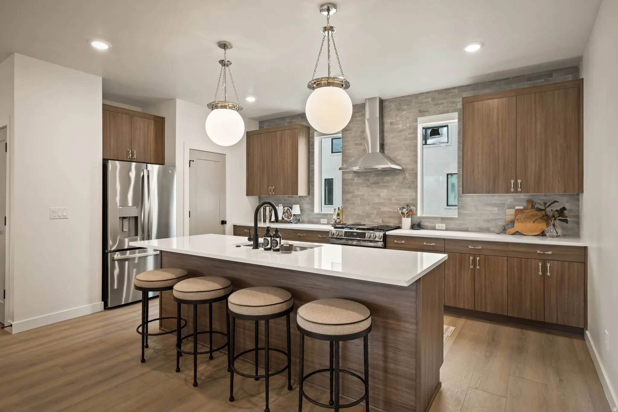 Kitchen featuring wood-finish cabinetry, stainless steel appliances, a center island with a white countertop, and pendant lighting