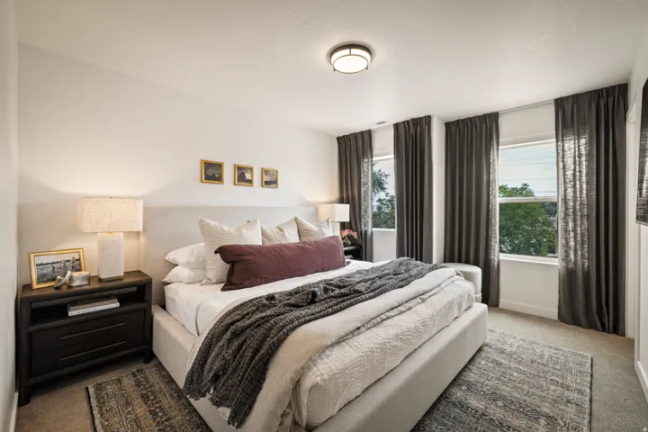 Recessed lighting, three large windows, and neutral wall finishes