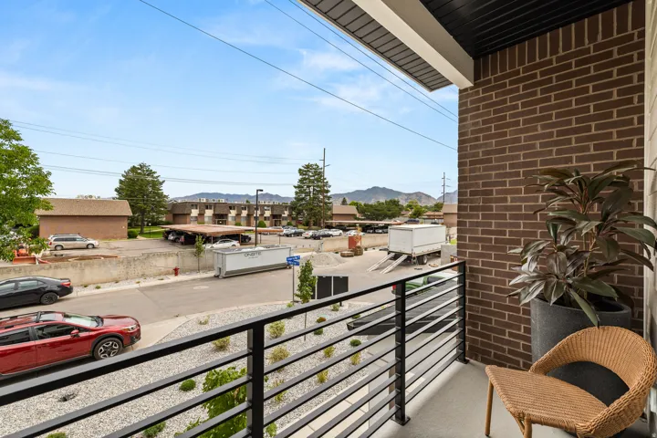 Private balcony with modern horizontal railings and brown brick exterior wall