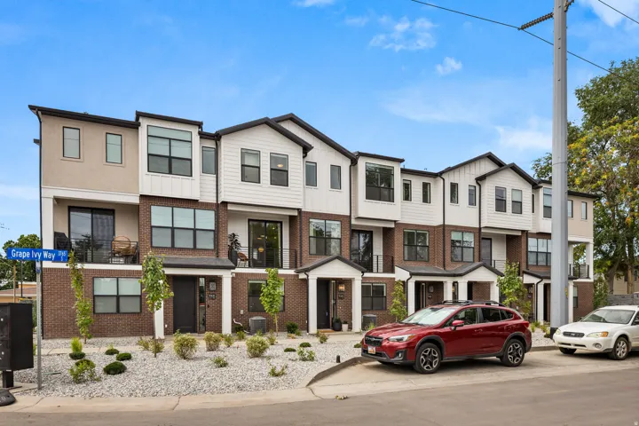 Contemporary townhome facade featuring a brick and siding exterior