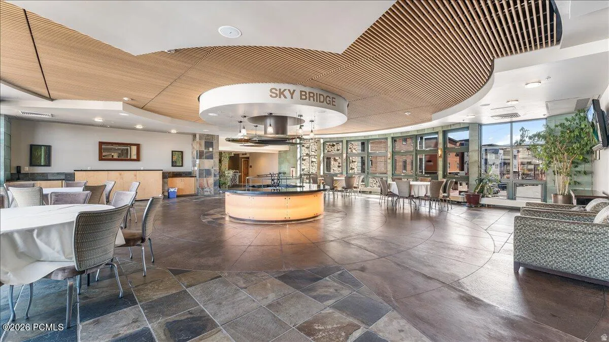 Spacious common area featuring slate tile flooring, wood slat ceiling detailing, and ample natural light from extensive windows