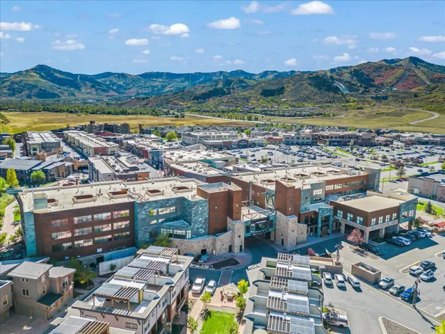 Community showcasing multi-story buildings, extensive surface parking areas, and surrounding natural landscapes