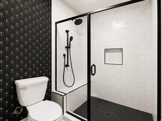 Glass-enclosed shower with a black frame and built-in bench