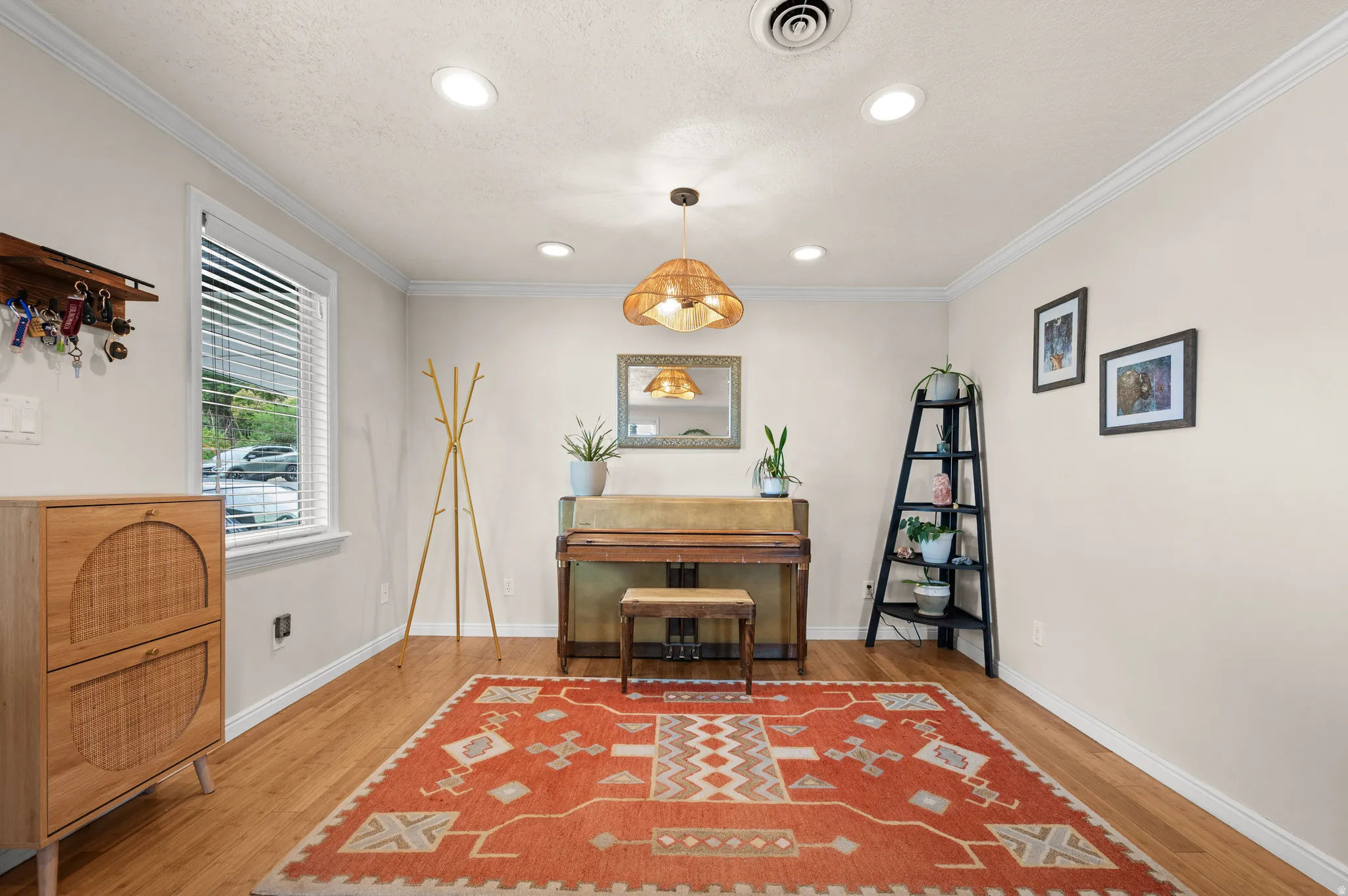 Recessed lighting, crown molding, wood-finish flooring, and a single window with blinds