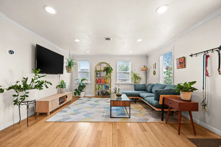 Recessed lighting, crown molding, multiple windows, wood-finish flooring, and white interior walls