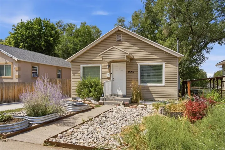 Single-story exterior with horizontal siding, a covered entry, and multiple windows