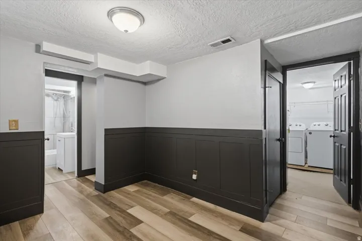Wood-finish flooring with dark wainscoting and light-painted walls