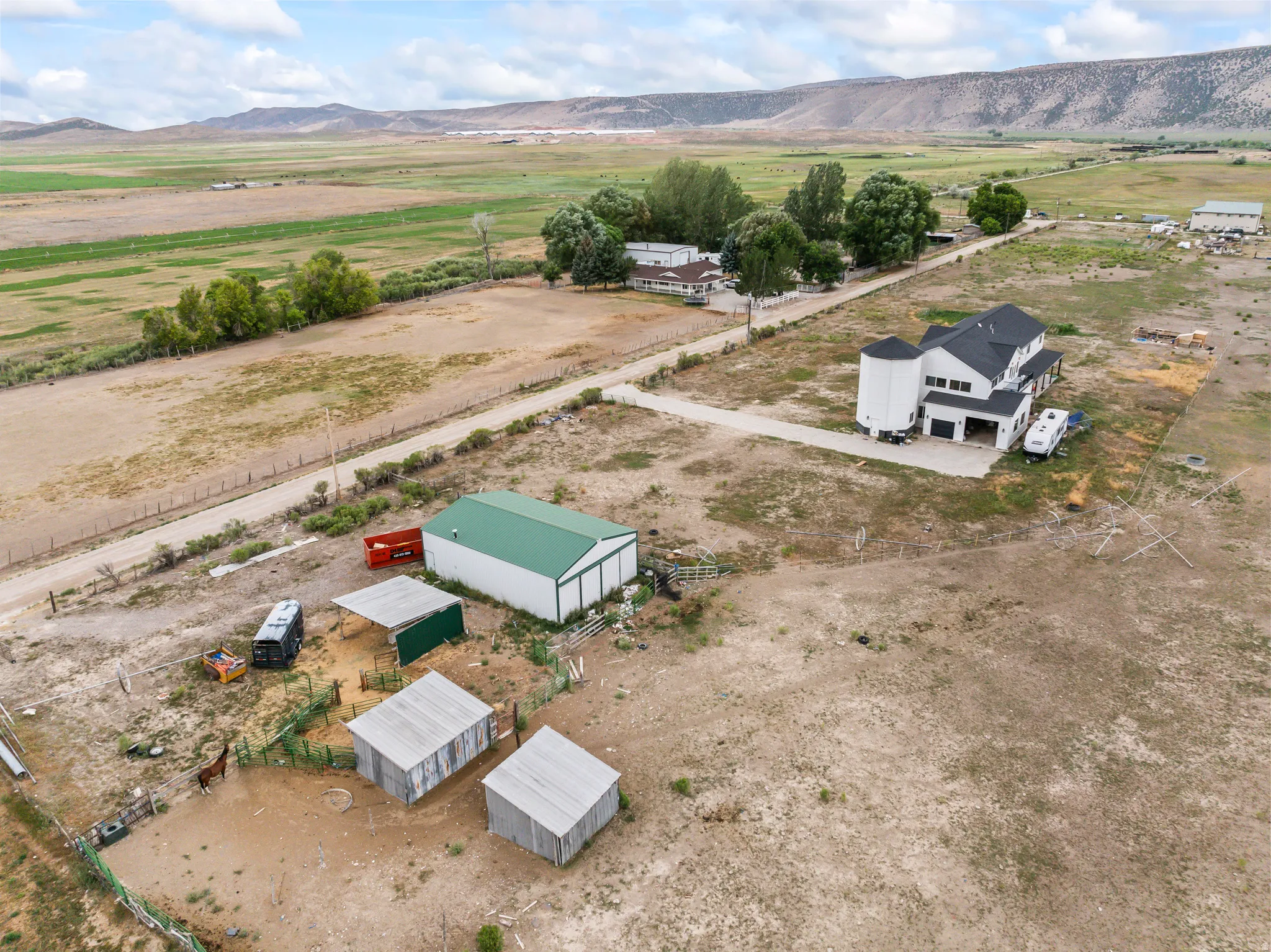 Expansive property featuring a multi-level residence with a silo-style architectural element and dark shingle roofing