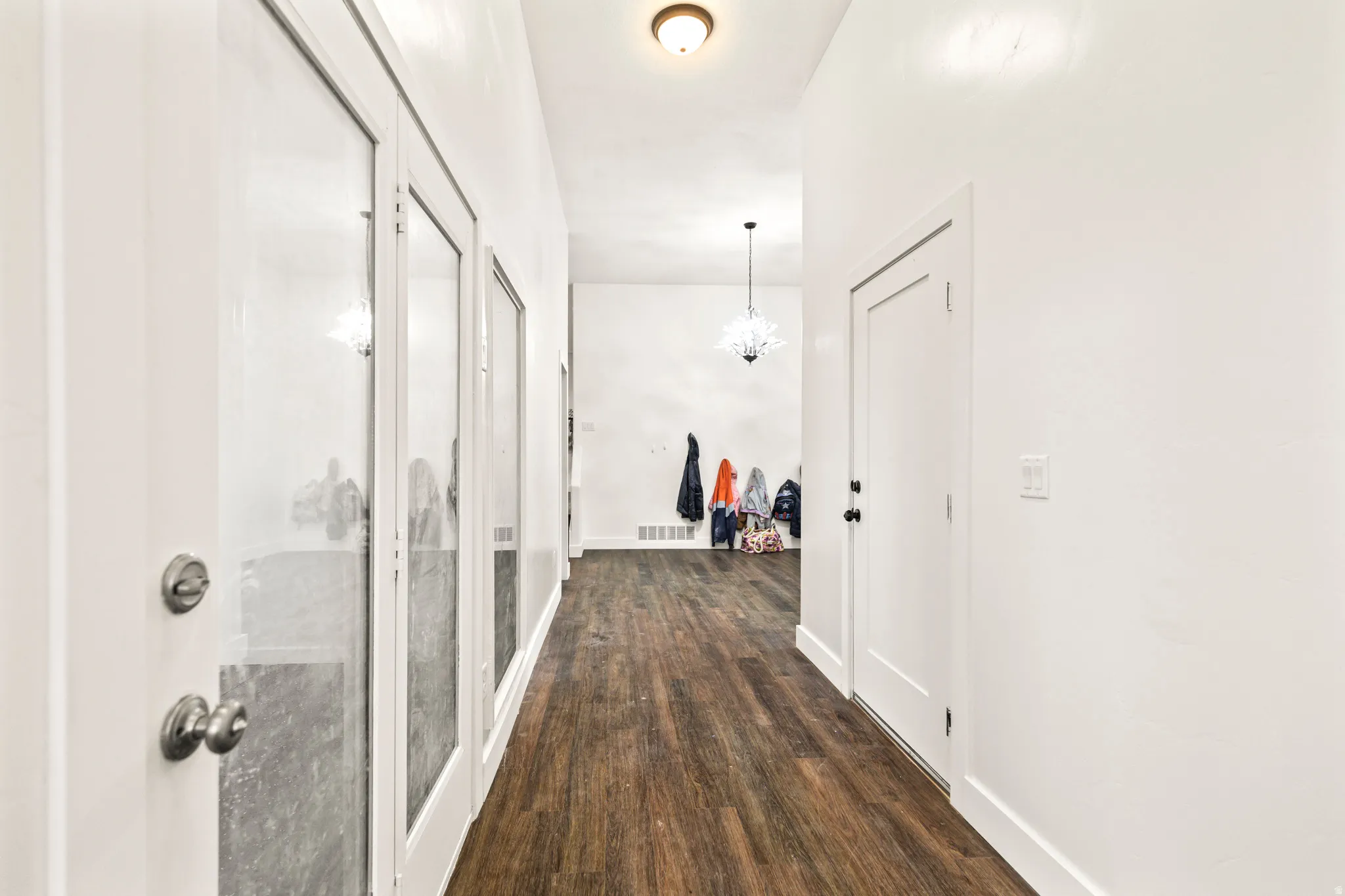 Hallway featuring wood-finish flooring, white walls, and recessed lighting