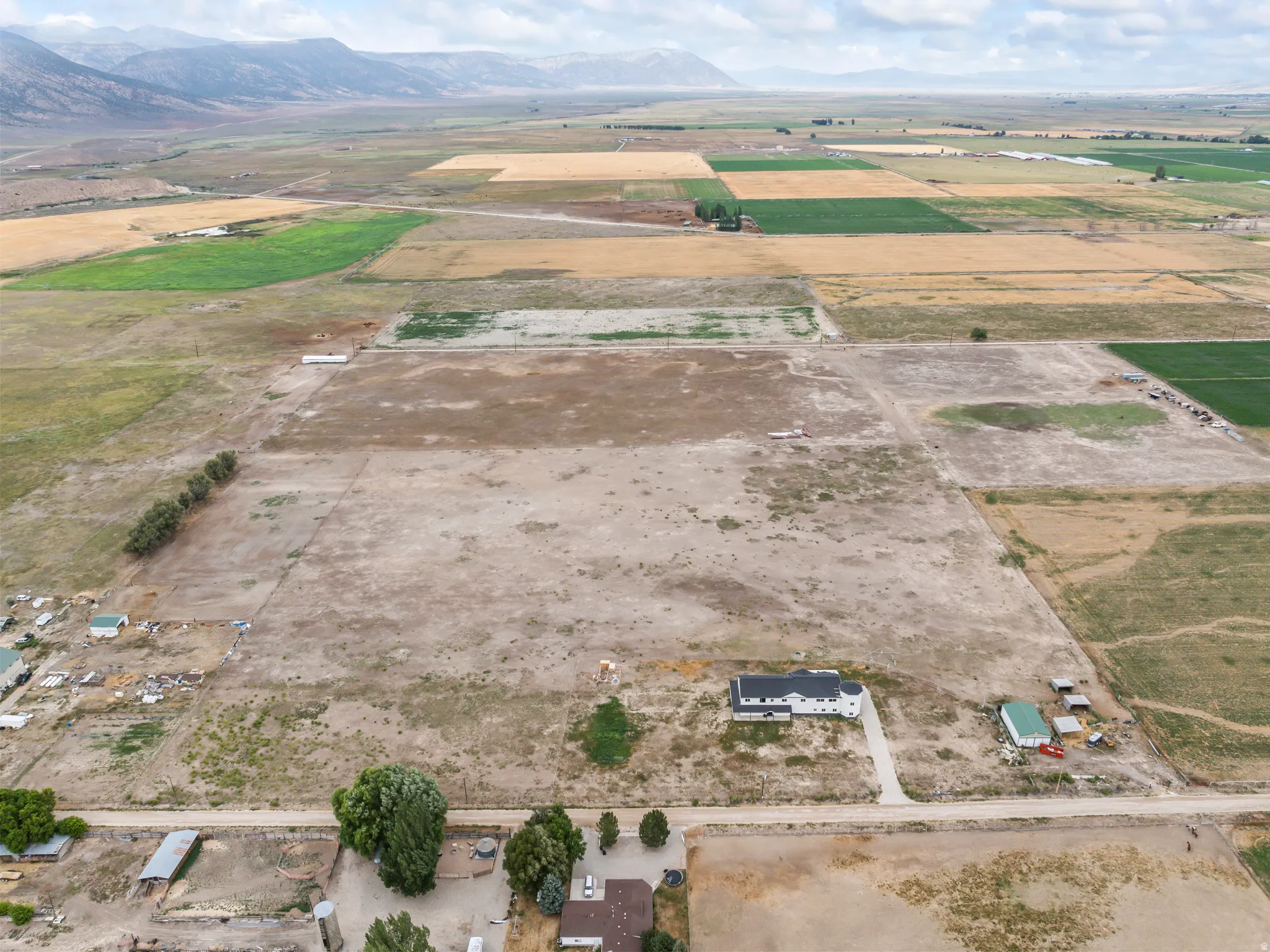 Expansive agricultural land featuring varied crop fields and distant mountains