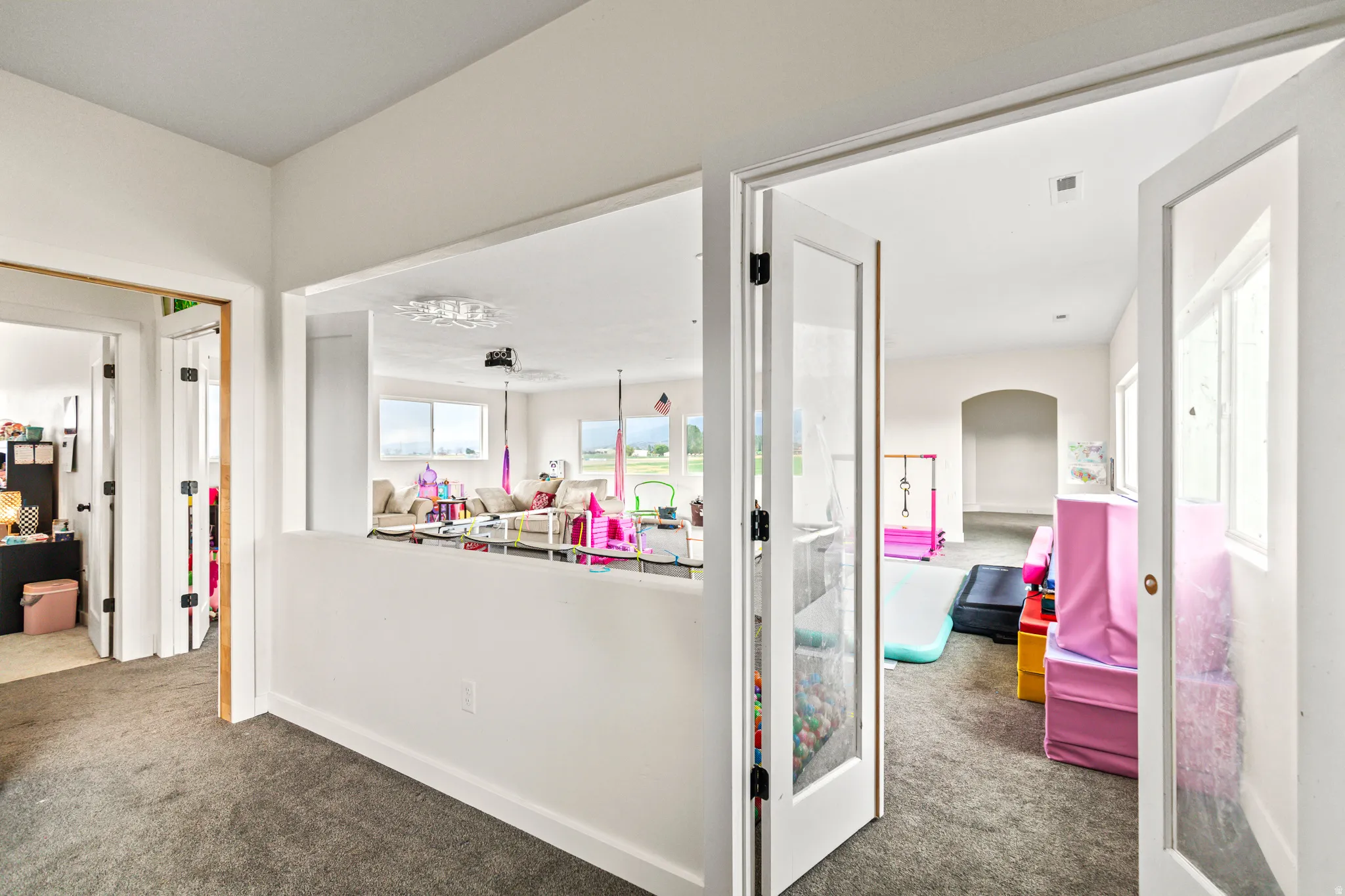 Dual glass-paneled doors, arched entryway, and an interior pass-through window