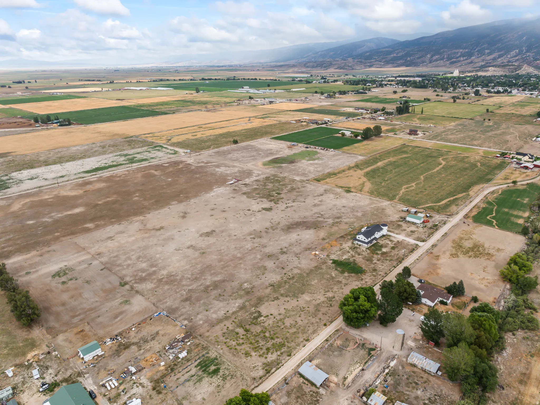 Expansive land parcel with surrounding agricultural fields and distant mountainous terrain