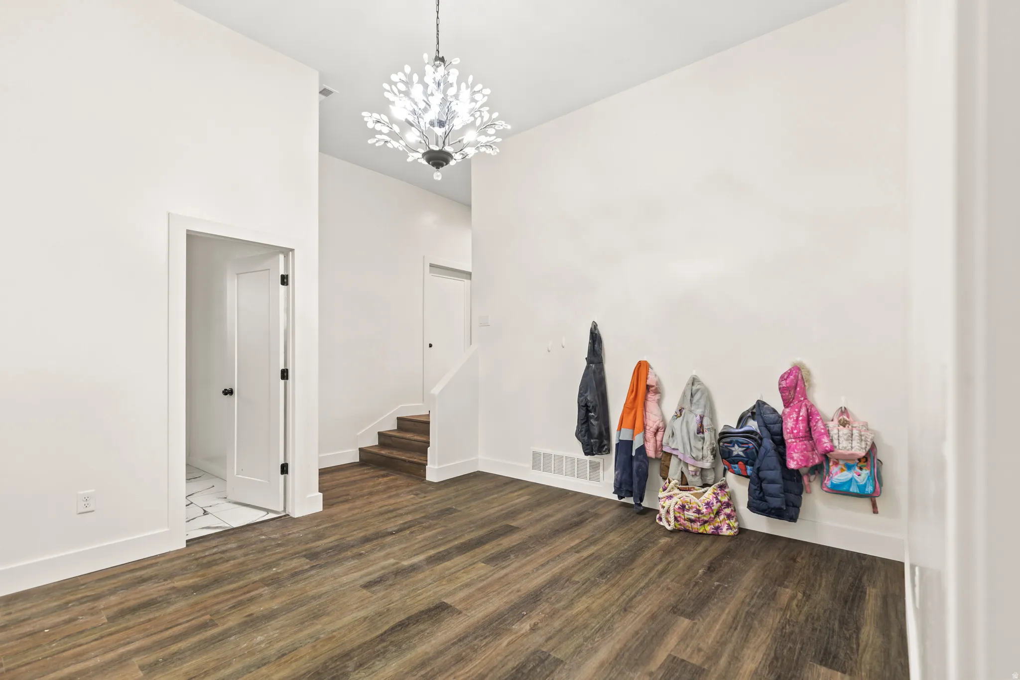 Wood-finish flooring, high ceilings, and a decorative ceiling fixture