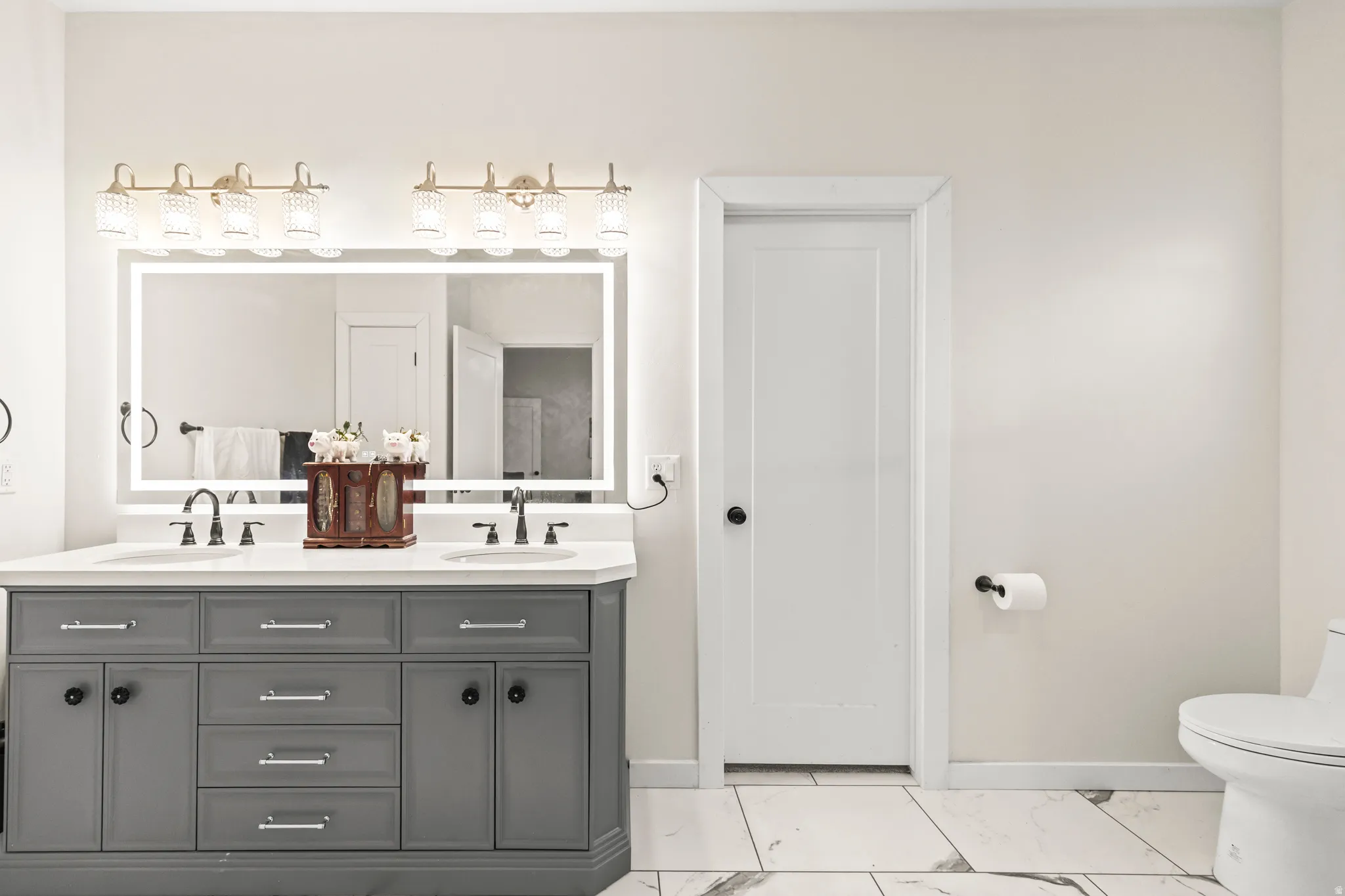 Dual vanity with gray cabinetry, white countertop, and dual undermount sinks