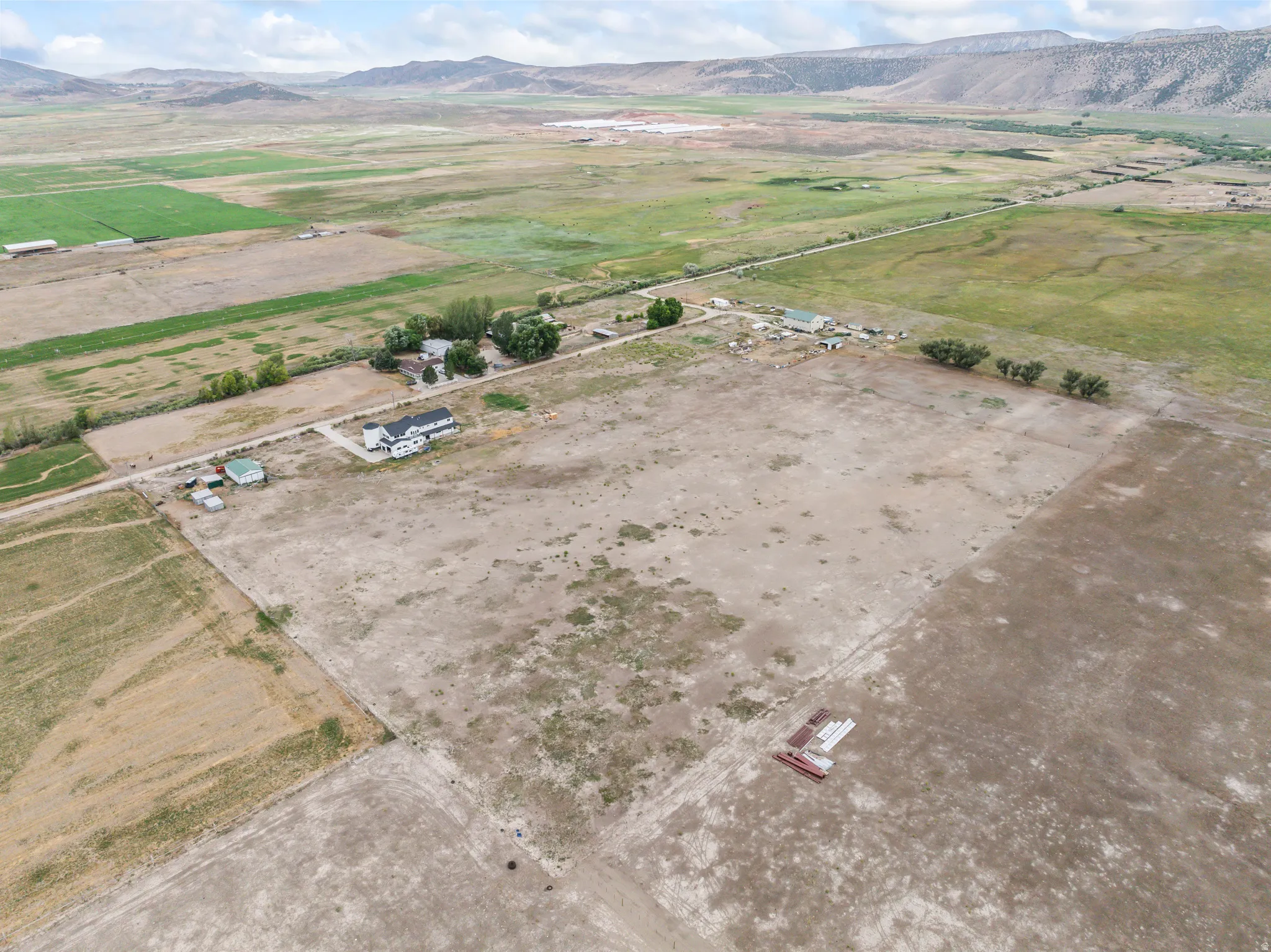 Expansive rural property featuring a main residence, multiple outbuildings, and surrounding agricultural land