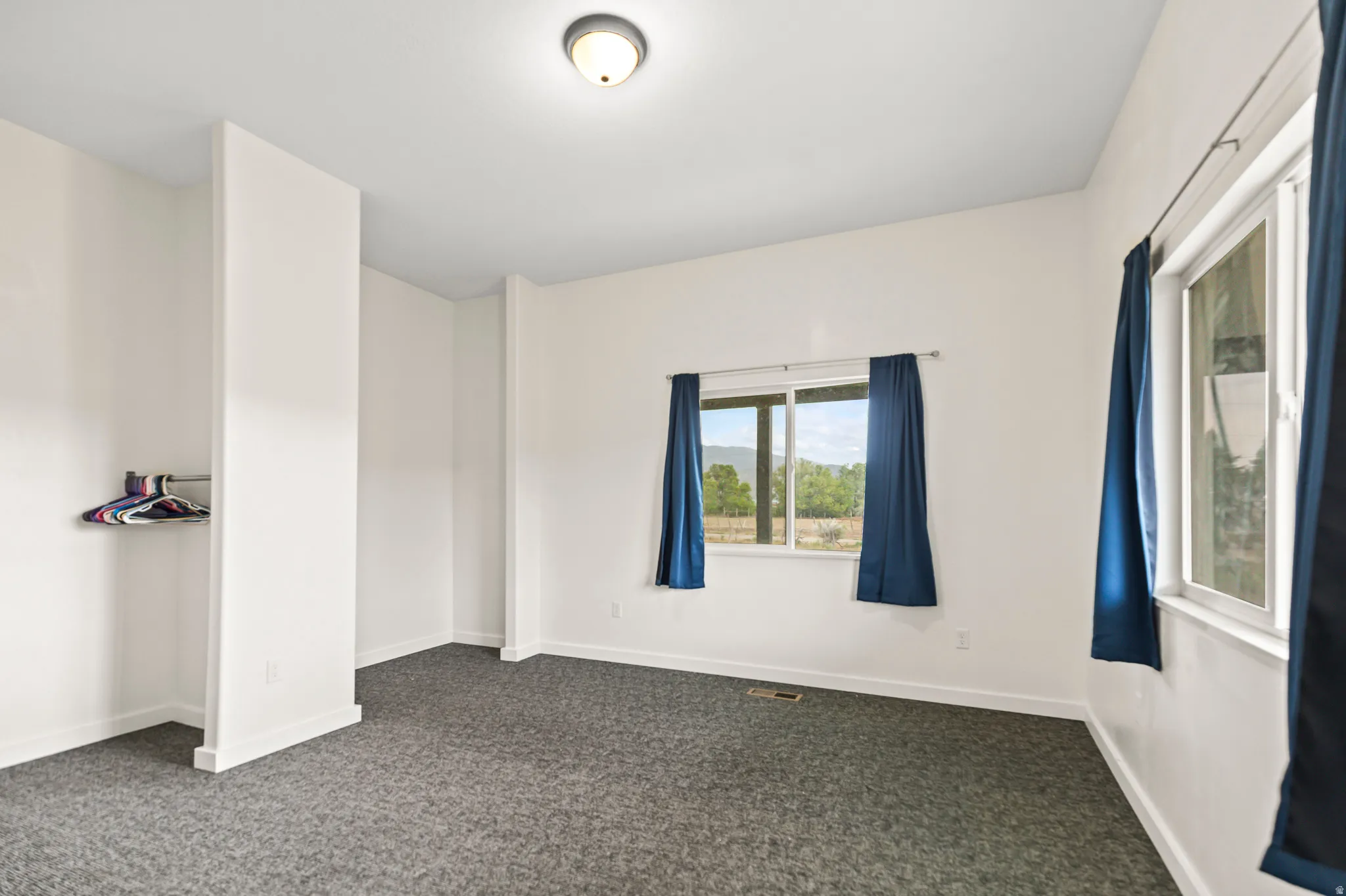 Recessed lighting, light-colored walls, and gray carpeting
