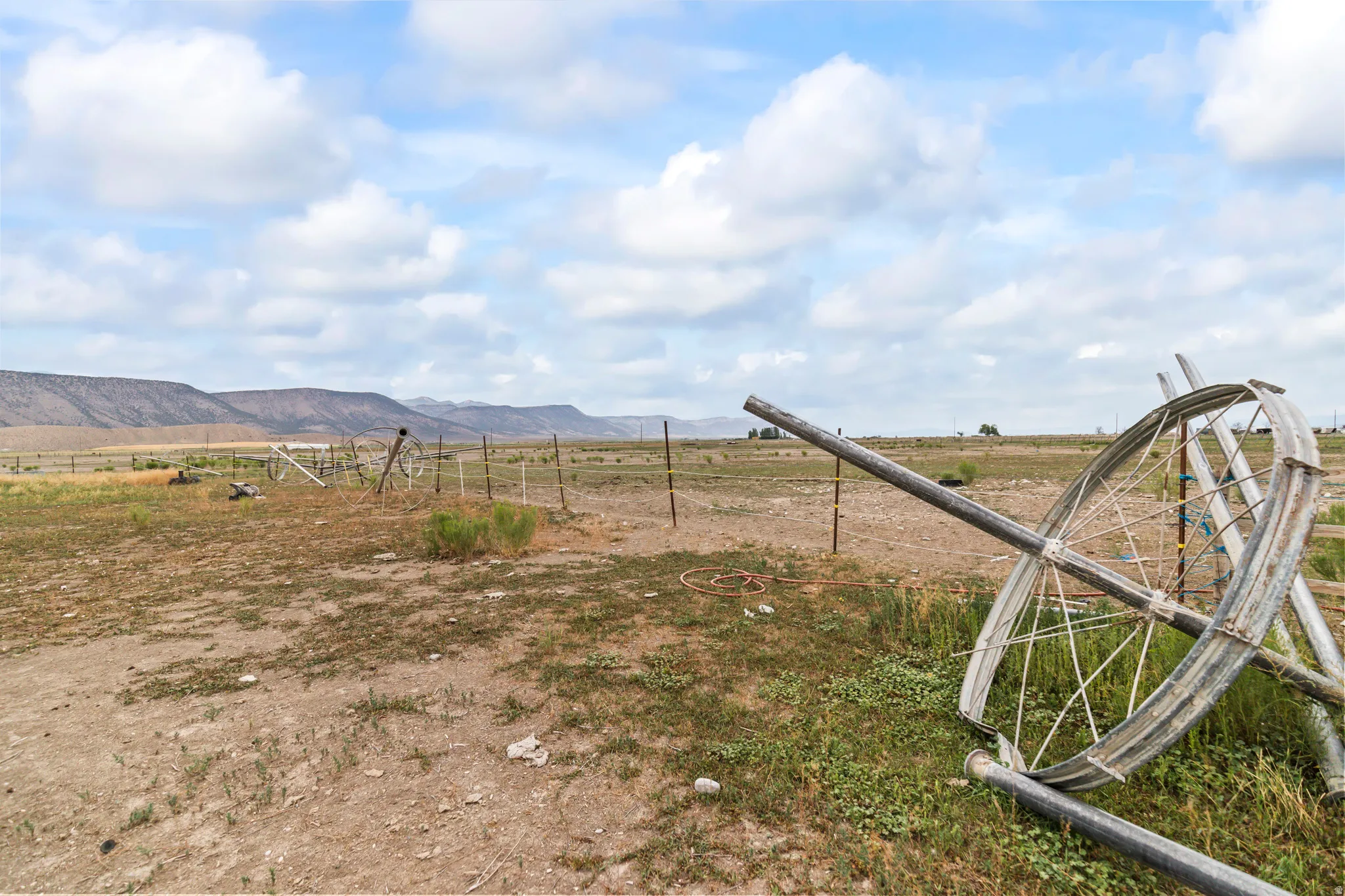 Expansive land parcel featuring distant mountain ranges and a partially fenced perimeter