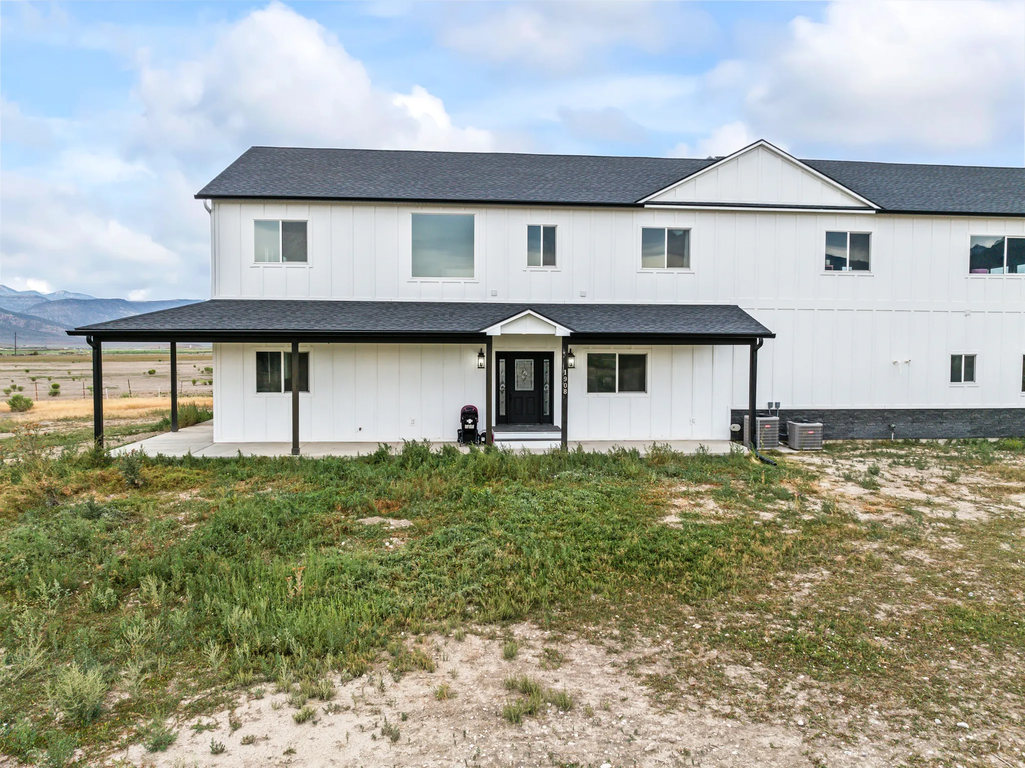 Contemporary two-story exterior with white vertical siding and dark trim