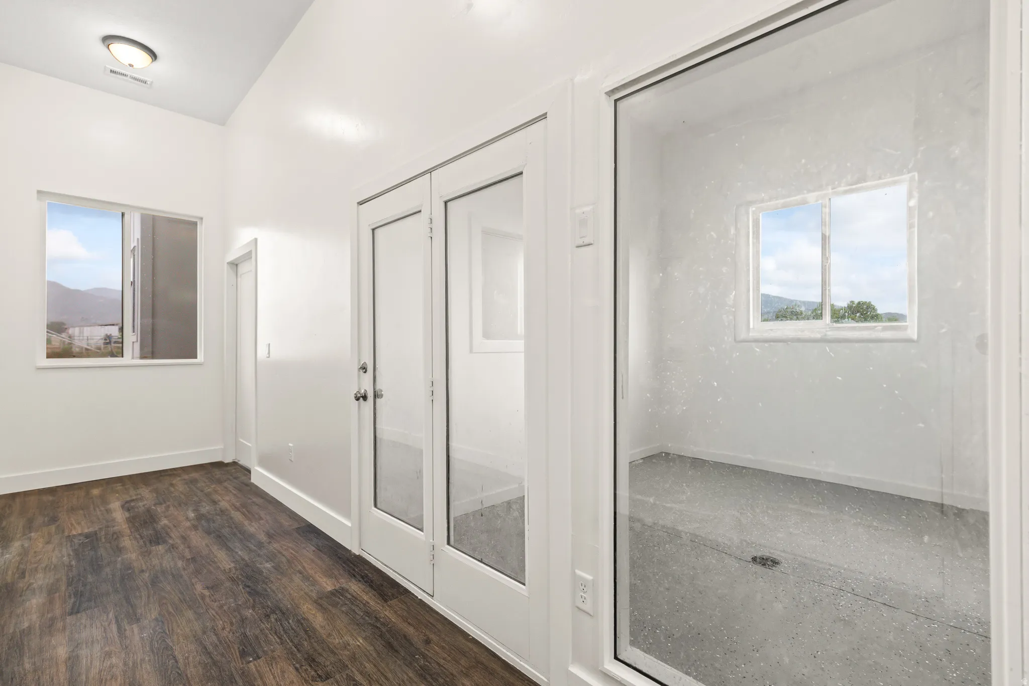 Wood-finish flooring, white walls, and a window with a mountain backdrop