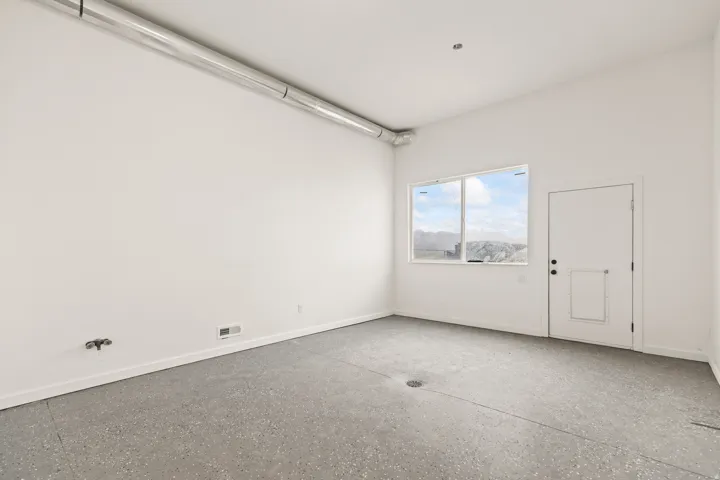 Polished concrete flooring, exposed overhead ductwork, and a window with mountain scenery