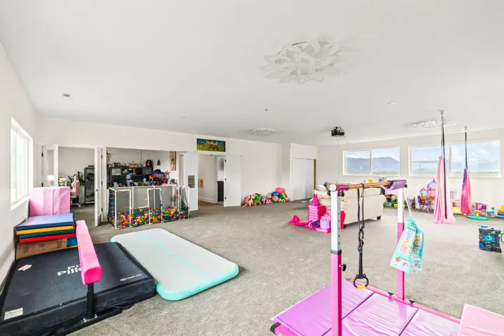 Expansive carpeted room featuring multiple windows, white walls, and decorative ceiling lighting