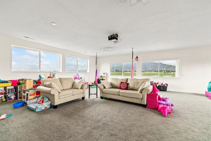 Expansive room featuring multiple horizontal windows, recessed lighting, and soft gray carpeting