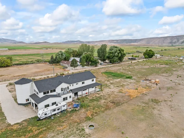Expansive property featuring a two-story residence with dark roofing, a white exterior, and an attached silo structure