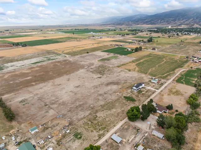 Expansive land parcel with surrounding agricultural fields and distant mountainous terrain