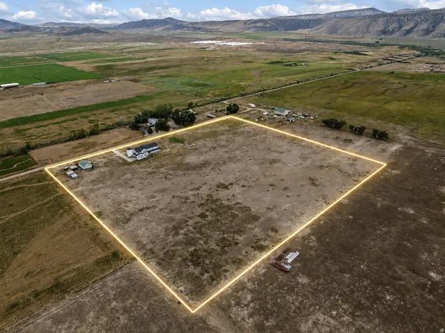 Expansive rural property featuring a main residence, multiple auxiliary structures, and surrounding agricultural land