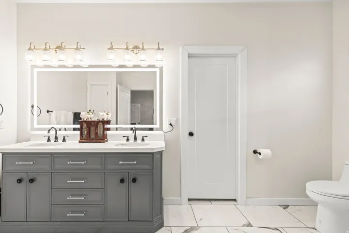 Dual vanity with gray cabinetry, white countertop, and dual undermount sinks