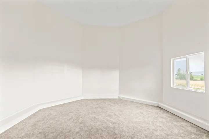 Wall-to-wall carpeting with light-toned walls and trim, featuring a multi-pane window