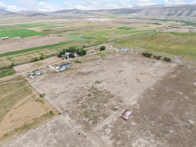 Expansive rural property featuring a main residence, multiple outbuildings, and surrounding agricultural land