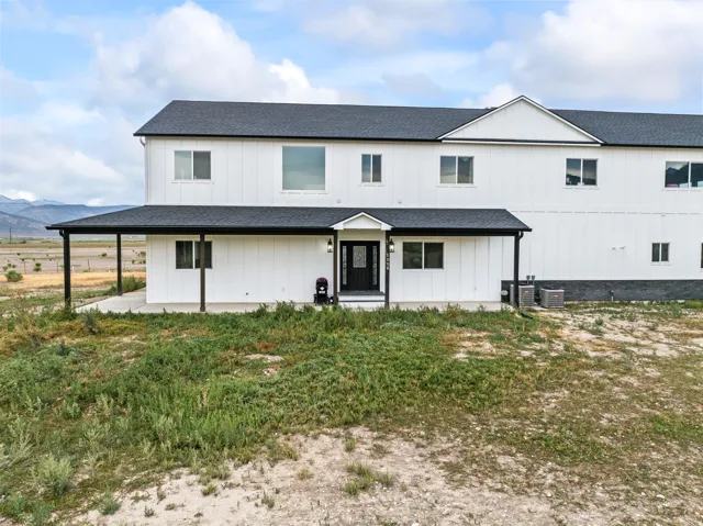 Contemporary two-story exterior with white vertical siding and dark trim